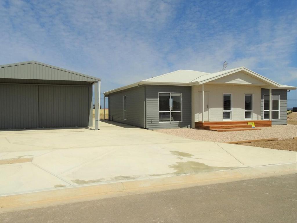 a house with a garage next to a driveway at Henri's Place in Wauraltee