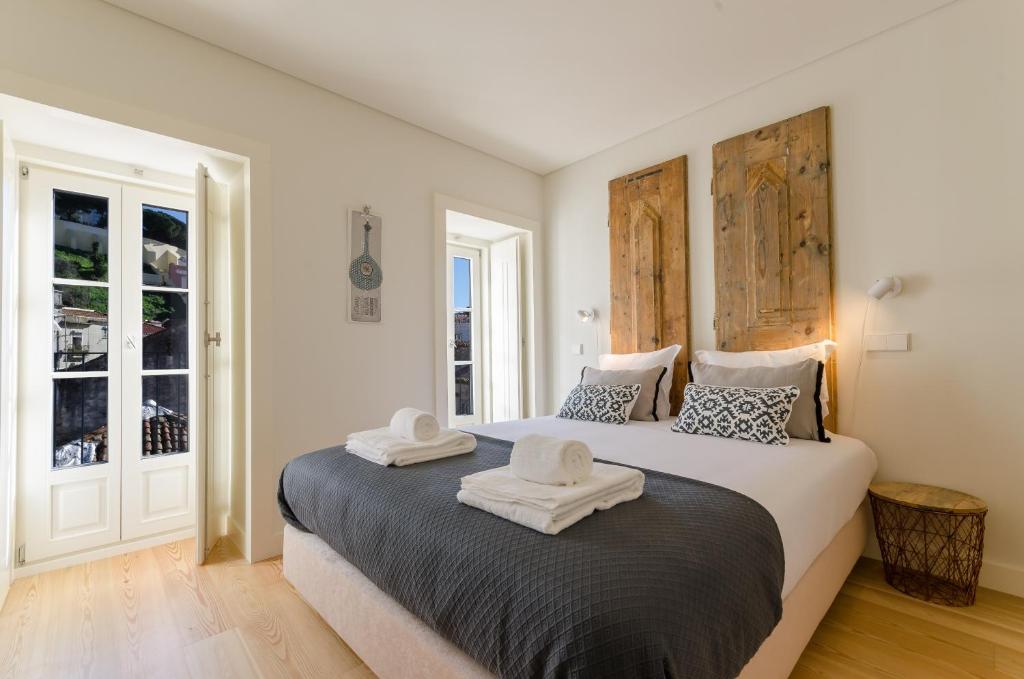 a bedroom with a large bed with two towels on it at Casas da Baixa - dAmouraria in Lisbon
