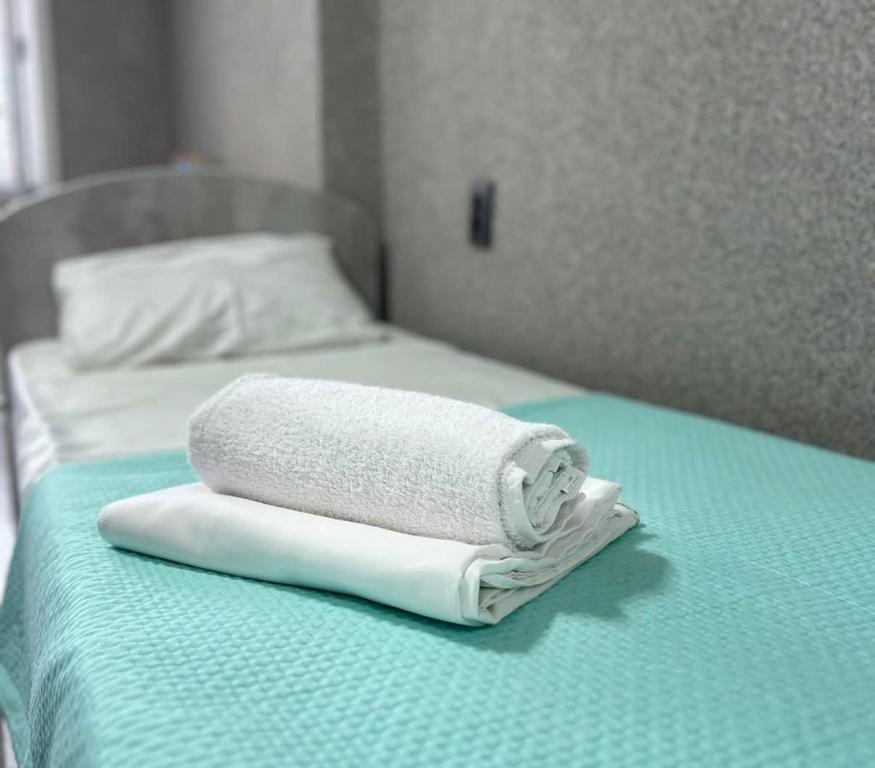 Una toalla está sentada encima de una cama. en Silk Way, en Semey
