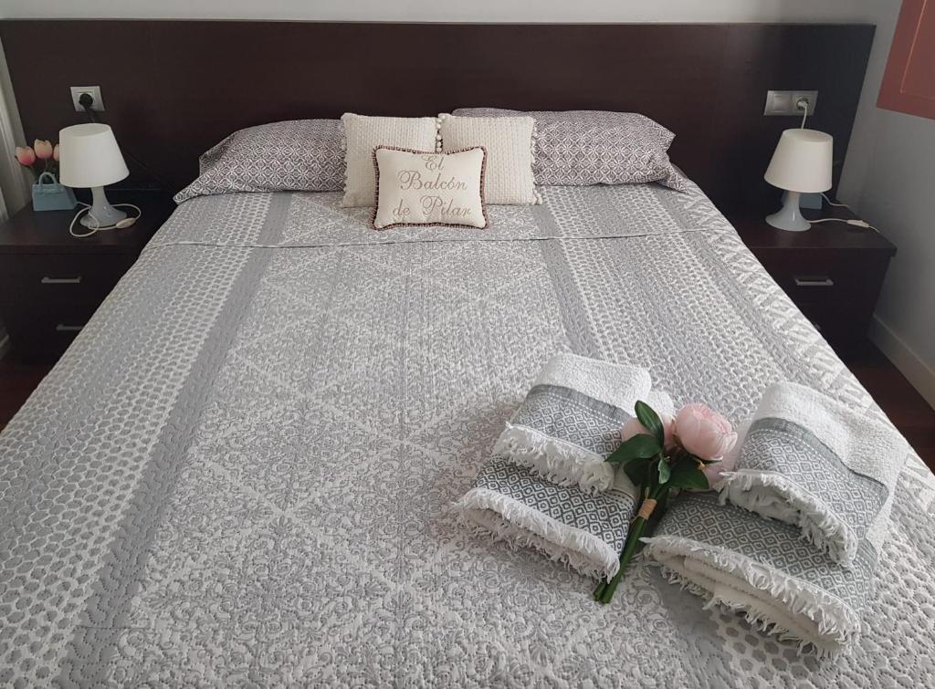 a bedroom with a bed with towels and pillows at El BALCÓN de PILAR in Zaragoza