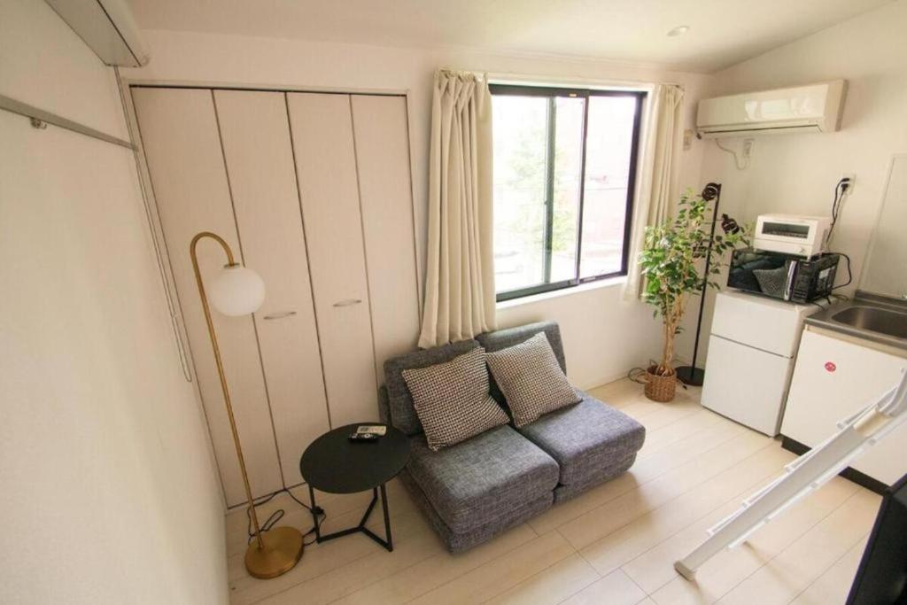 una pequeña sala de estar con sofá y ventana en SCS201, 20 mins to Skytree,30 mins to Ueno Ginza, en Tokio