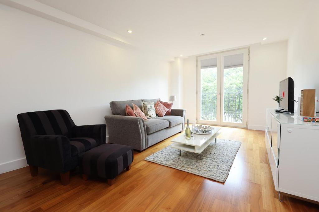 una sala de estar con un sofá y una silla en Central Cardiff Stay Near Everything!, en Cardiff