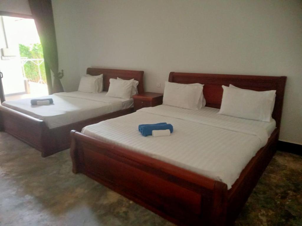 a bedroom with two beds with a blue item on them at Siem Reap Local Stay in Phumĭ Réach Born