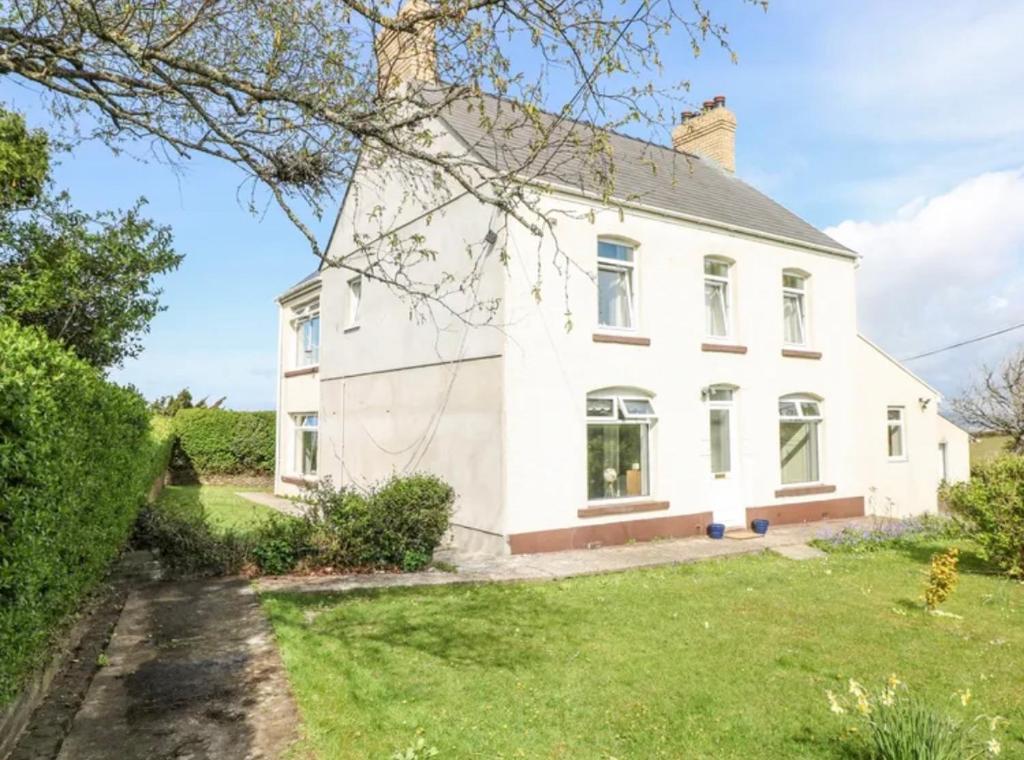 an image of a white house with a yard at Burry House North Gower in Llanmorlais