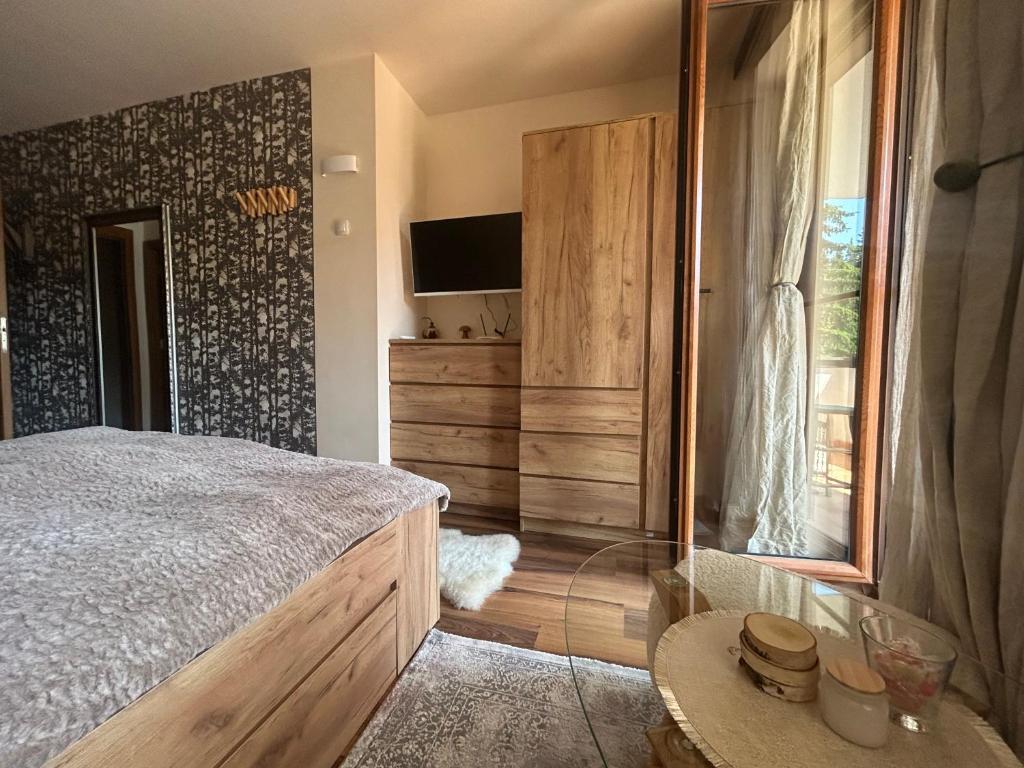 a bedroom with a bed and a tv on a wall at Bambi in Pamporovo