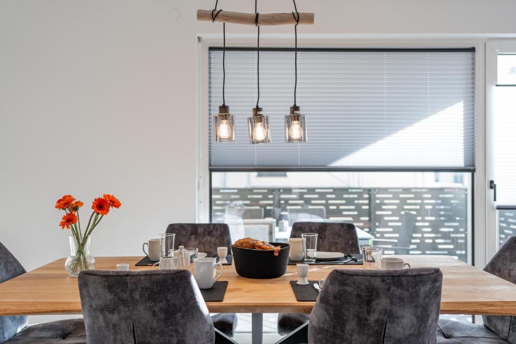 una sala da pranzo con tavolo e sedie in legno di BPS Apartment #10 Flair - NEU - Deluxe - Modern a Horb am Neckar