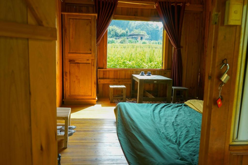 a room with a bed and a window and a table at Giay's Local House in Sapa
