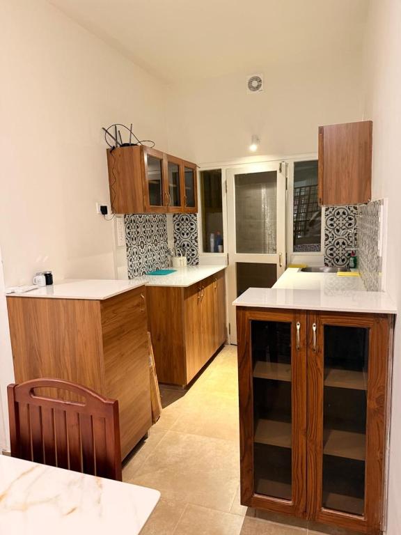 a kitchen with wooden cabinets and white counter tops at Hibiscus By Tara Suites in Jāmb
