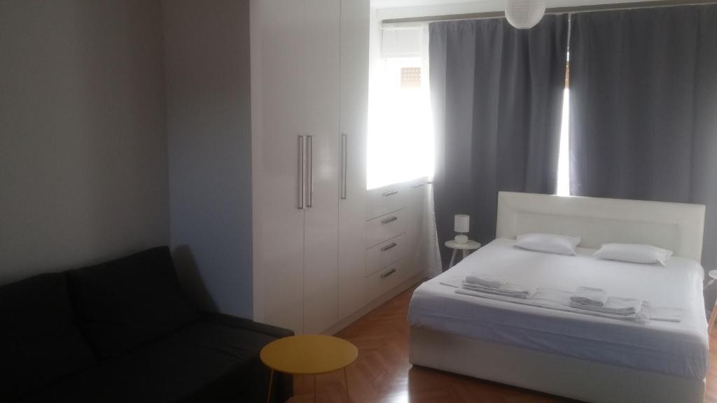 a bedroom with a white bed and a chair at Apartments Antonio in Split