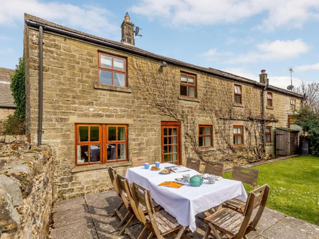 una mesa y sillas frente a una casa de piedra en 3 Bed in Nidderdale HH016, en Pateley Bridge