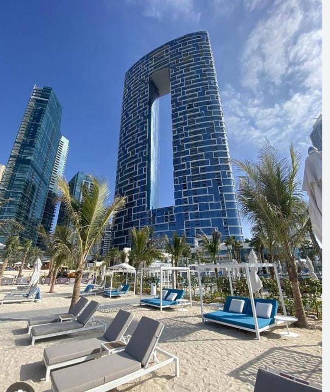 un edificio con sedie a sdraio e palme di fronte ad esso di Elegant 2BR Apt Address Beach Resort a Dubai