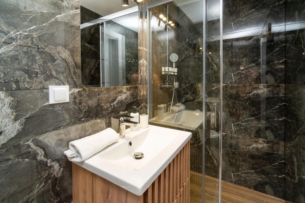 een badkamer met wastafel en douche bij Apartamenty pod Stokiem in Kluszkowce