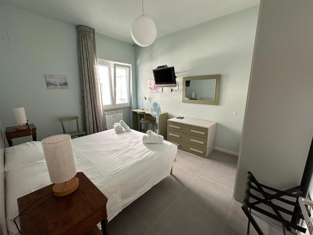 a bedroom with a white bed and a television at Mythos Holiday Home in Campobasso