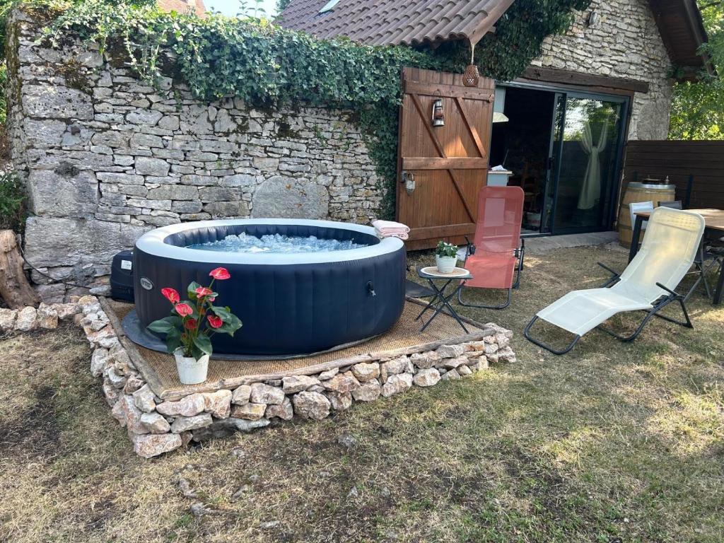 a large blue tub sitting in a yard with a chair at La Cazelle, charme sport et détente in Saint-Chels