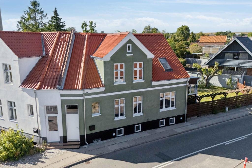 a house with an orange roof on the side of a street at Holiday Home With Billiards, Garden, Great Spot in Grenå