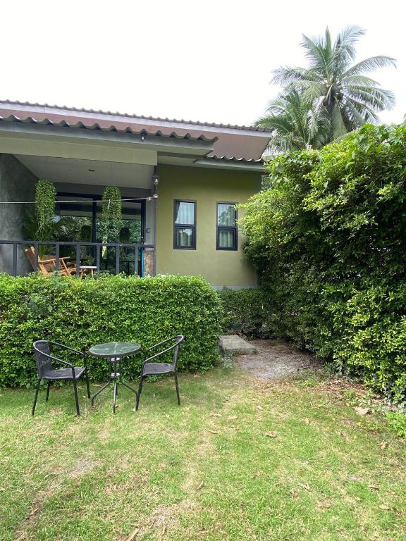 a table and two chairs in front of a house at Green & Pink Garden Homes in Ko Phangan
