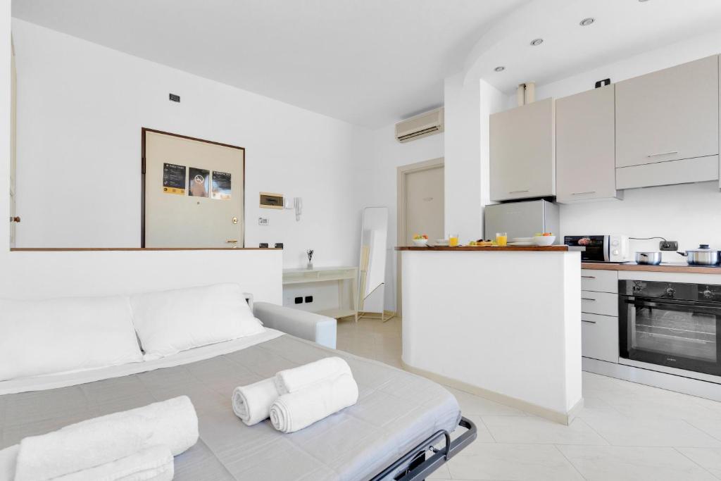 una cucina bianca con un letto in una camera di Navigli - Porta Ticinese - Luminoso monolocale a Milano