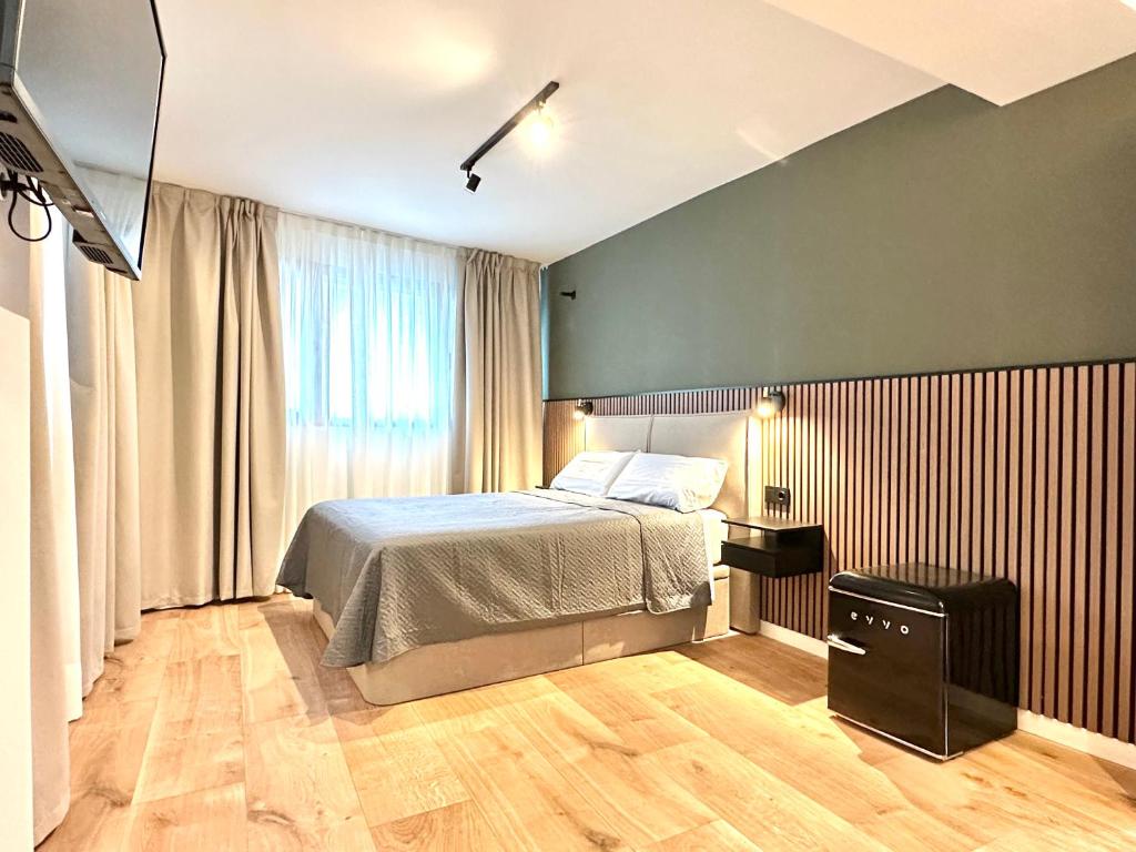 a bedroom with a bed and a television in it at Akasa Rooms Rambla in Alicante