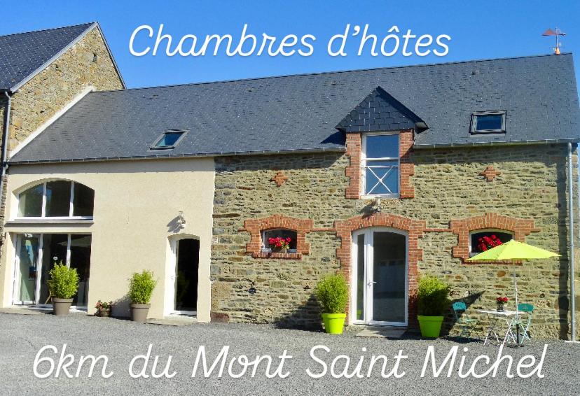 une maison en briques avec les mots cham dun mont saint michel dans l'établissement Le Relais de la Hardiesse 6km Mont St Michel - Chambres d'hôtes doubles, à Courtils