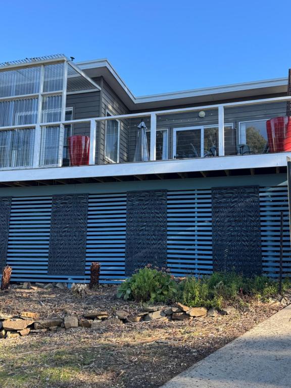 a house with blue shutters on the side of it at Views of the Tamar River in Clarence Point