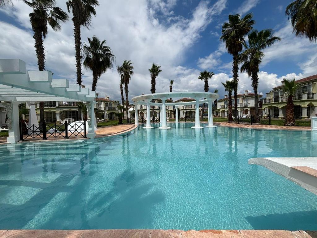 einen großen Pool mit Pavillon und Palmen in der Unterkunft Villa B&D Lou in Fethiye