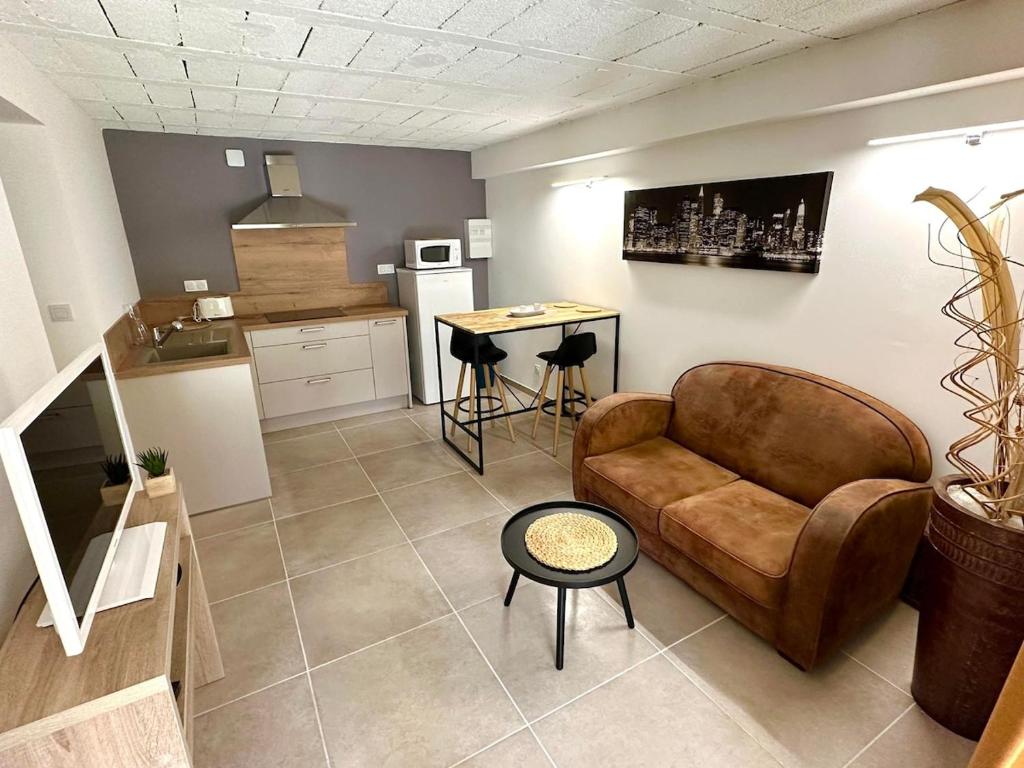 a living room with a couch and a kitchen at Nice App Private Parking, Garden, Furnished Terrace in Châteauneuf-du-Rhône