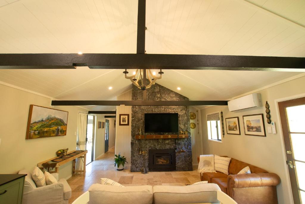 a living room with a couch and a fireplace at Ceffyl Cottage in Gheerulla