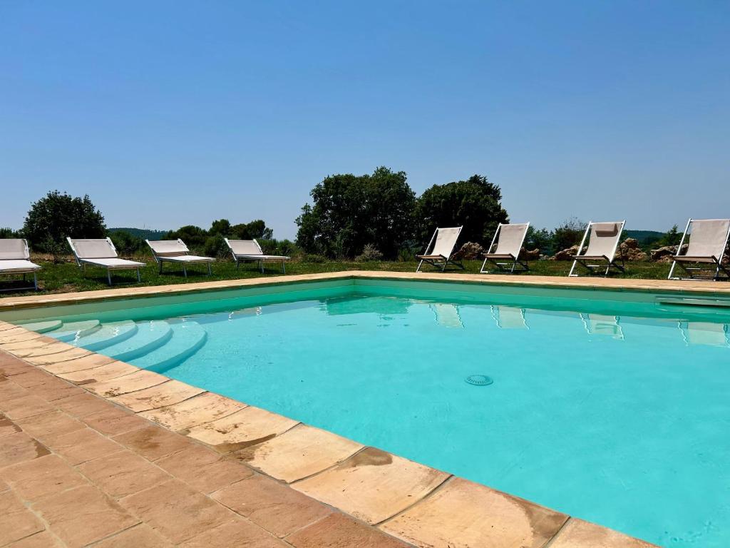 a large swimming pool with lounge chairs at Il Paglieto - Natura, Stelle, Relax e Piscina in Manciano
