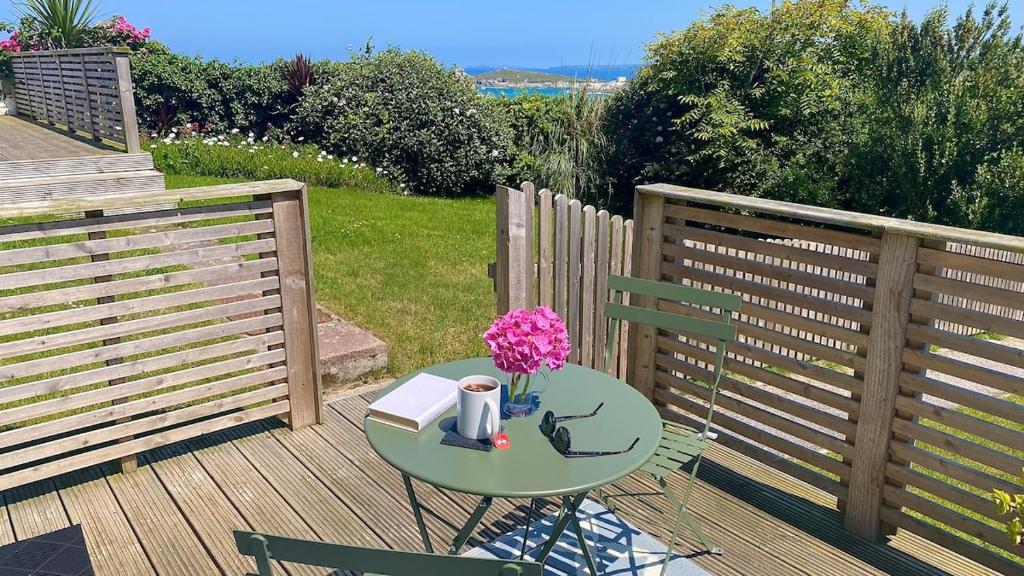 ニューキーにあるSea view Studio by Fistral Beachのデッキの上に本と花が置かれたテーブル