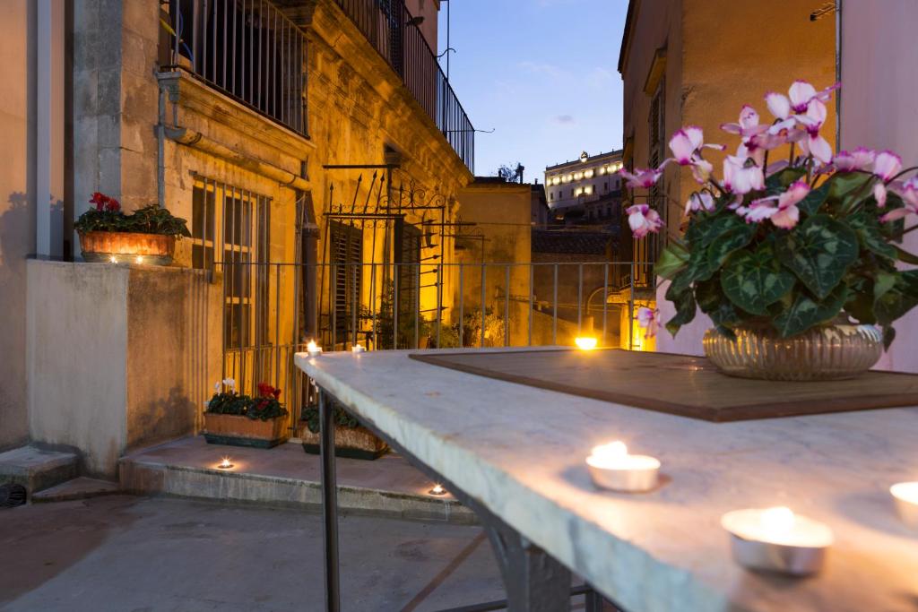 モーディカにあるI Balconi sul Baroccoのバルコニーにキャンドルと花のテーブル