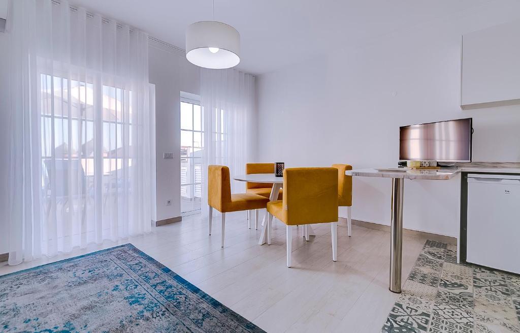 a kitchen and dining room with a table and chairs at Apartamentos Sol & Ria in Olhão