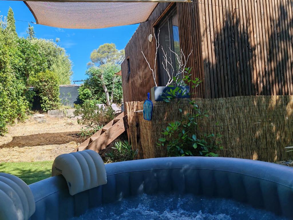 - un bain à remous dans une cour à côté d'une clôture dans l'établissement Joli studio climatisé avec jacuzzi privé et entrée indépendante, à Fréjus