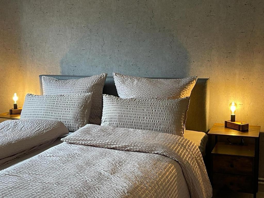 a bedroom with two beds with white sheets and two lamps at Bi Jöns in St. Peter-Ording