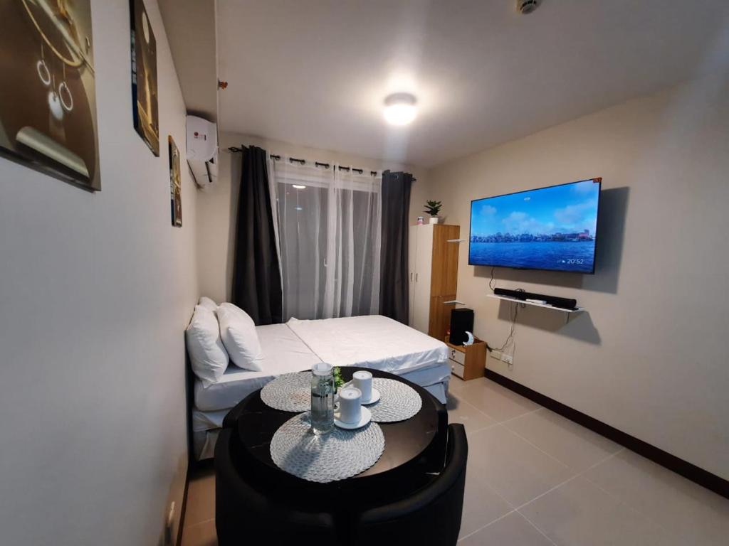 Zimmer mit einem Bett und einem Tisch mit einem TV in der Unterkunft JJL Suites Daily Rental in Suba