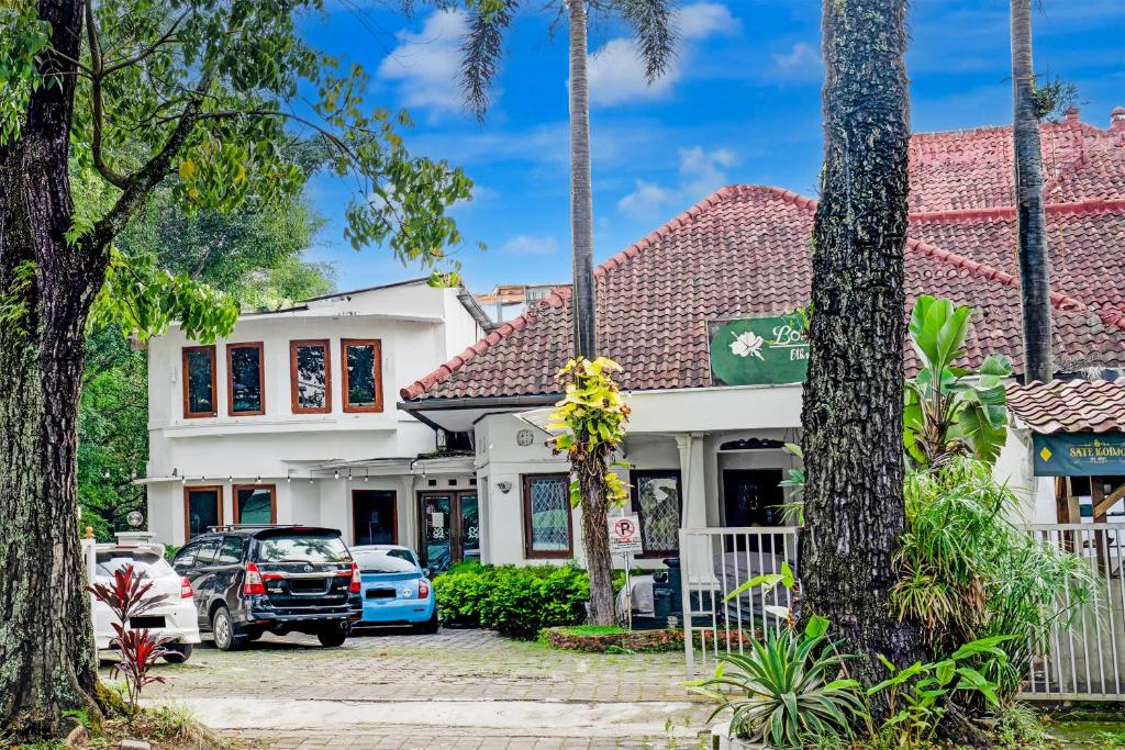 a house with cars parked in front of it at Dancenter The Ethnic Hotel in Bandung