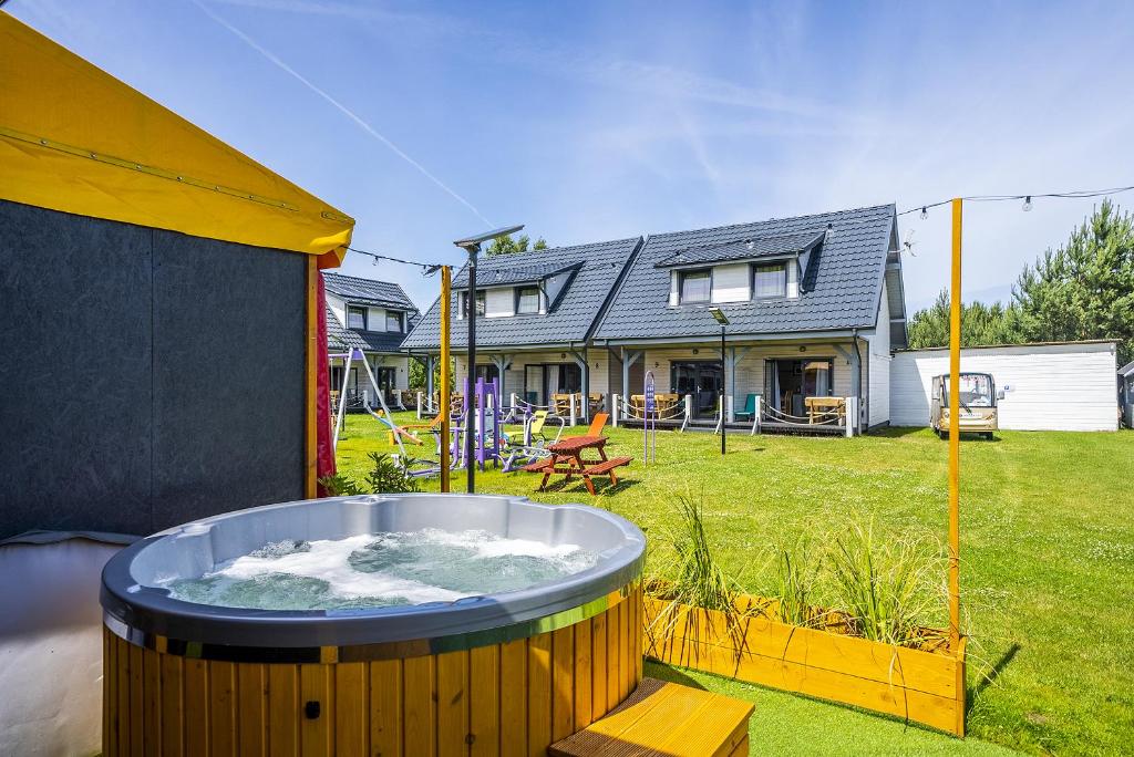 a hot tub in the yard of a house at Domki letniskowe Marengo in Lubiatowo
