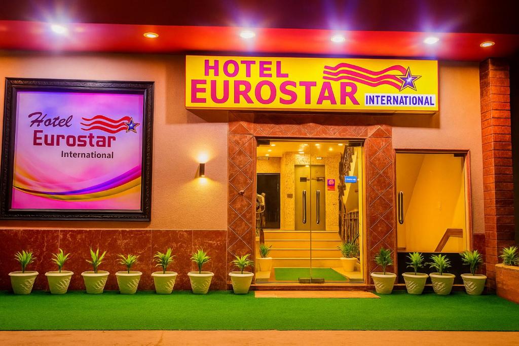 a hotel entrance with potted plants in front of it at Hotel Eurostar International By Quality Inn in New Delhi