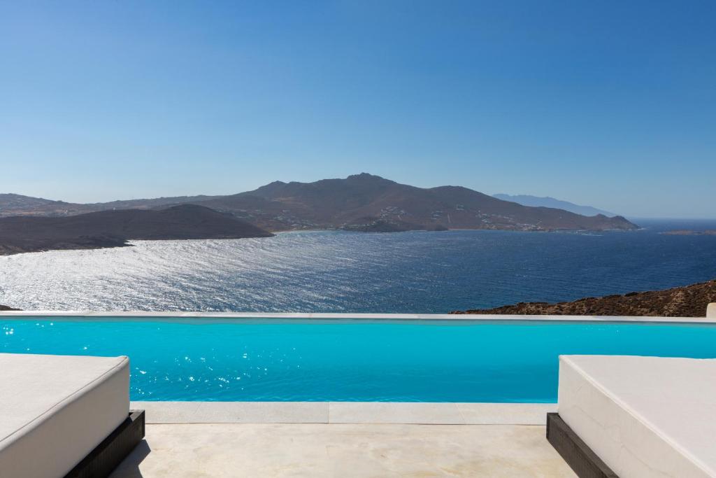 a swimming pool with a view of the ocean at Amazē Mykonos in Mikonos