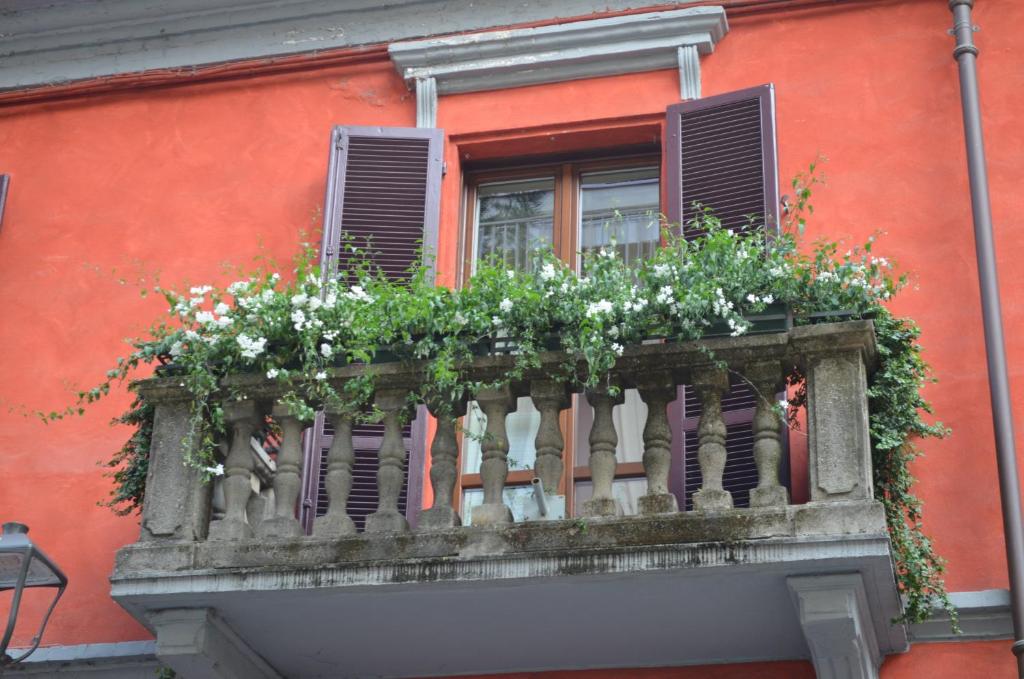 a balcony with flowers on a red building at Apartment Alfieri in Alba
