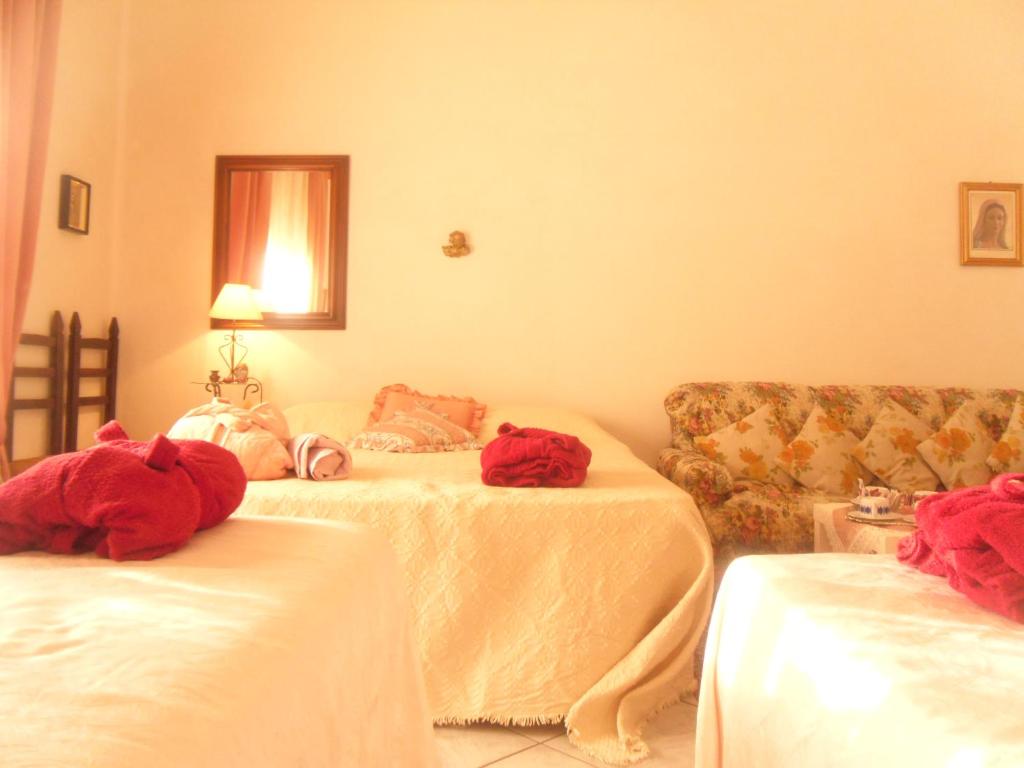 a living room with two beds and a couch at ITALIA GUESTHOUSe in Milis