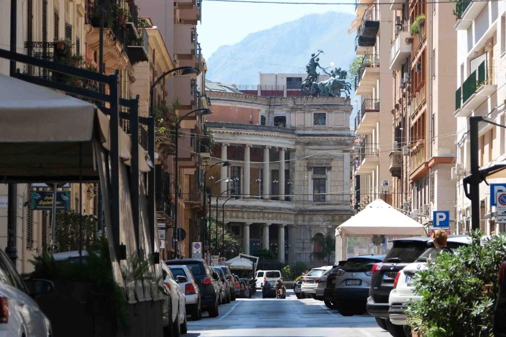 a city street with parked cars and a building at Mazzini Suites Palermo in Palermo