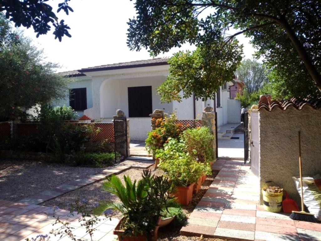 a house with a fence and some plants in a yard at Bilo Lu Rattali in San Teodoro