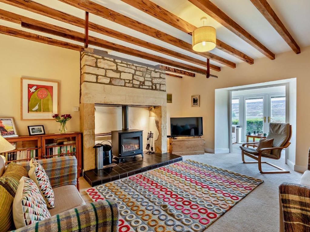 a living room with a fireplace and a couch at 3 Bed in Alnwick 93171 in Edlingham