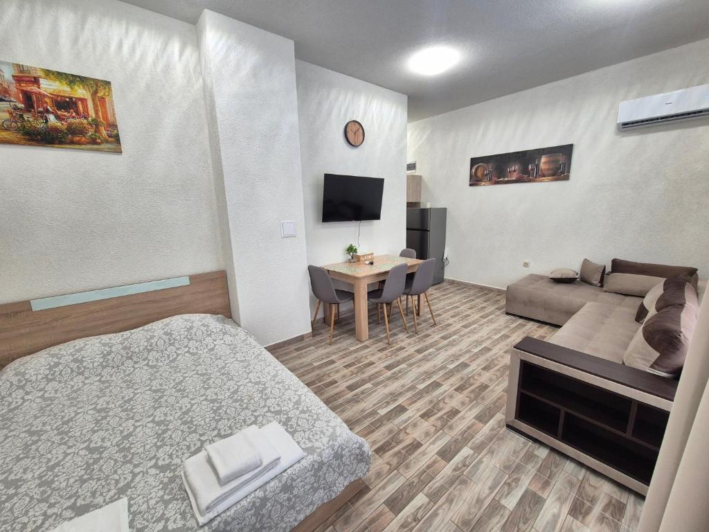 a hotel room with a bed and a living room at Студио Лазур с Безплатен Паркинг in Pomorie