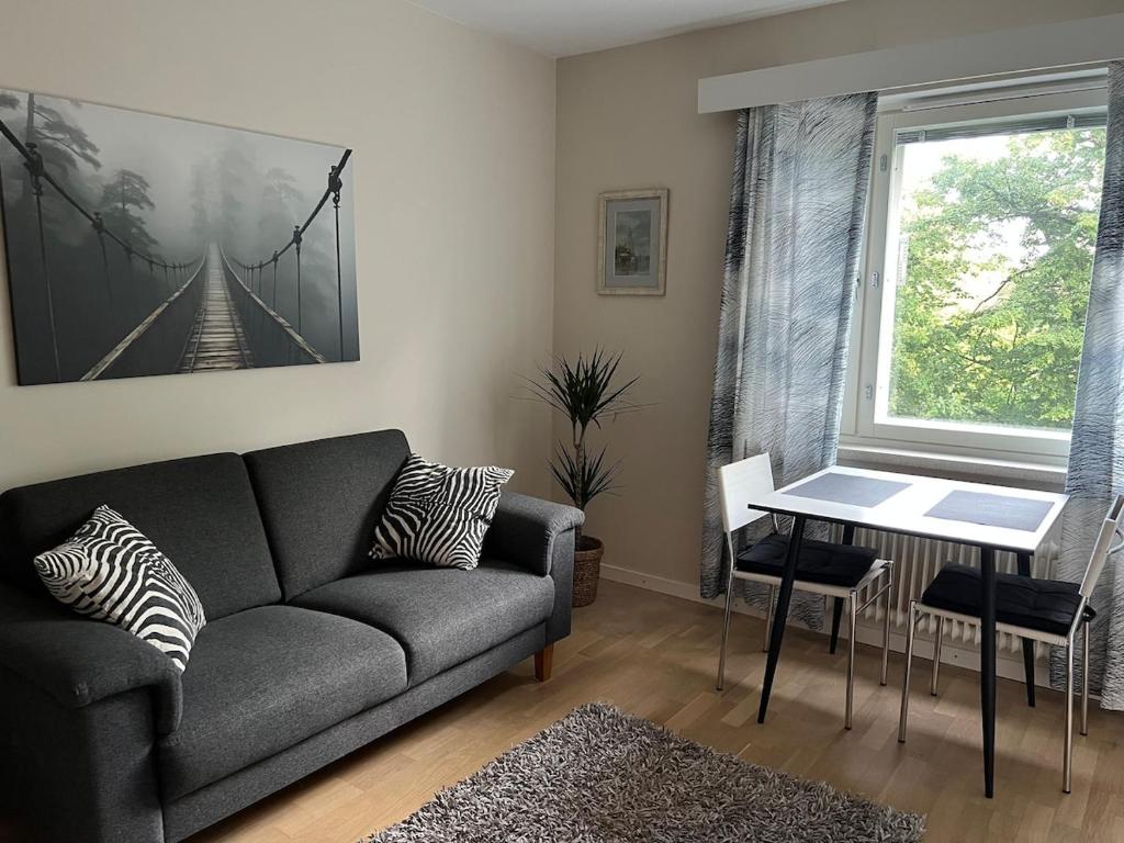 a living room with a couch and a table at Helsinki Punavuori Studio in Helsinki