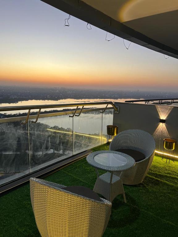 a patio with a table and chairs on a balcony at Eden Suite - 30th floor in Noida