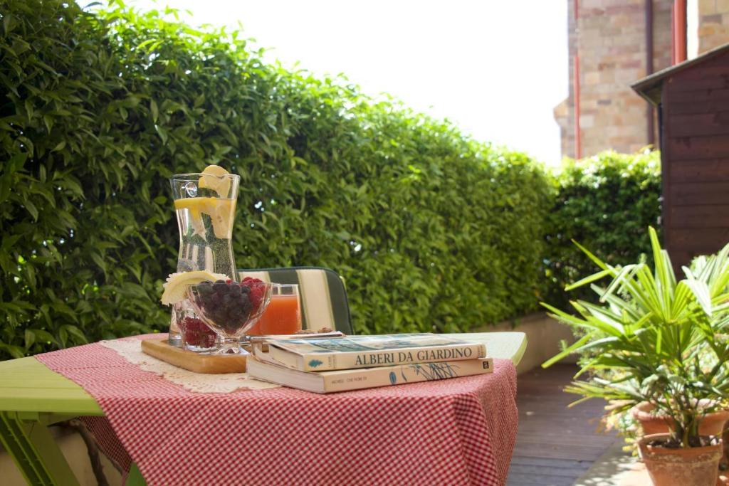 una mesa con libros y un jarrón encima en Appartamento Mandiri, en San Casciano in Val di Pesa