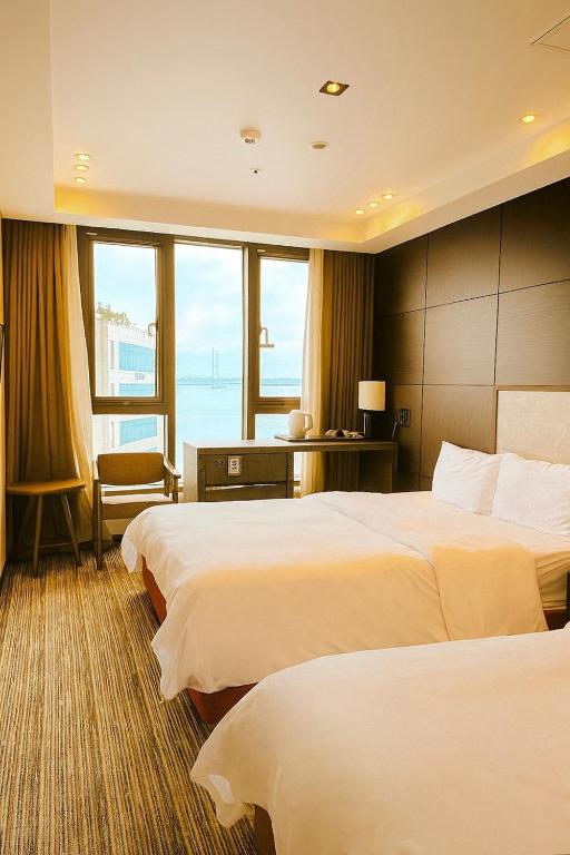 a hotel room with two beds and a large window at 웨스턴인터내셔널호텔 in Incheon