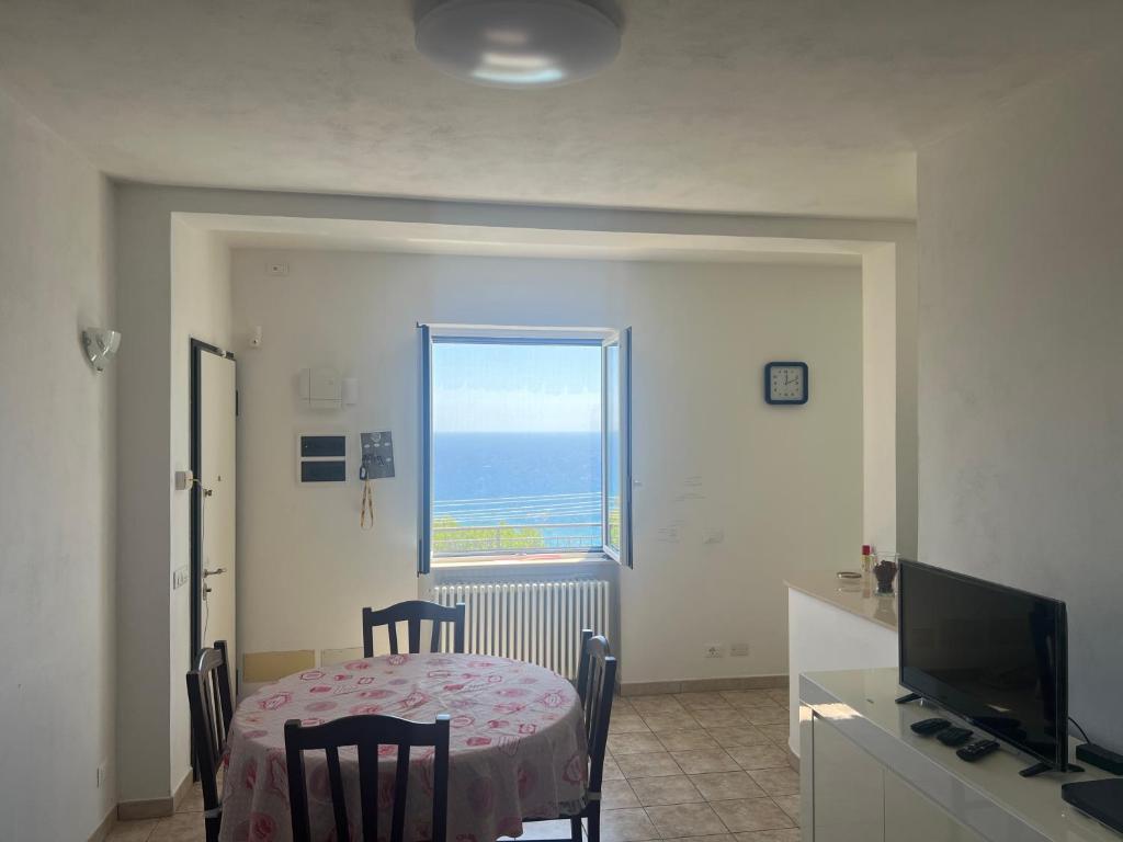 a dining room with a table and a window at Appartamento fronte mare in Poggi