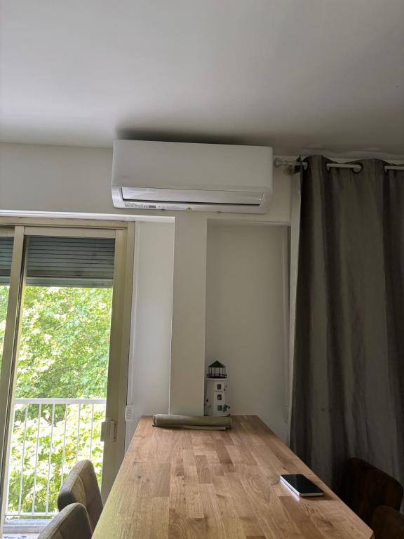 un salon avec une table et une fenêtre dans l'établissement 2 Pièces au cœur de Cagnes Sur Mer, à Cagnes-sur-Mer